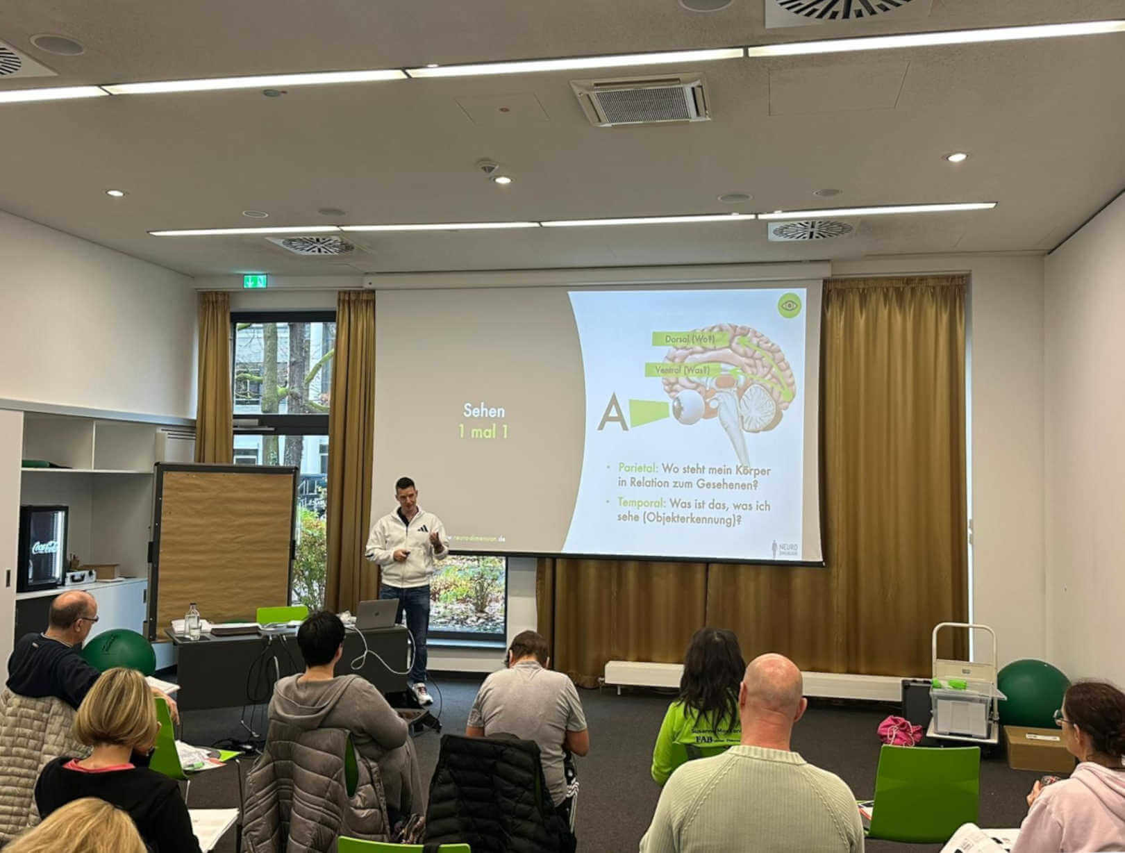 Kevin Grafen hält eine Inhouse-Schulung vor einer Leinwand, Teilnehmende hören dem Vortrag zu